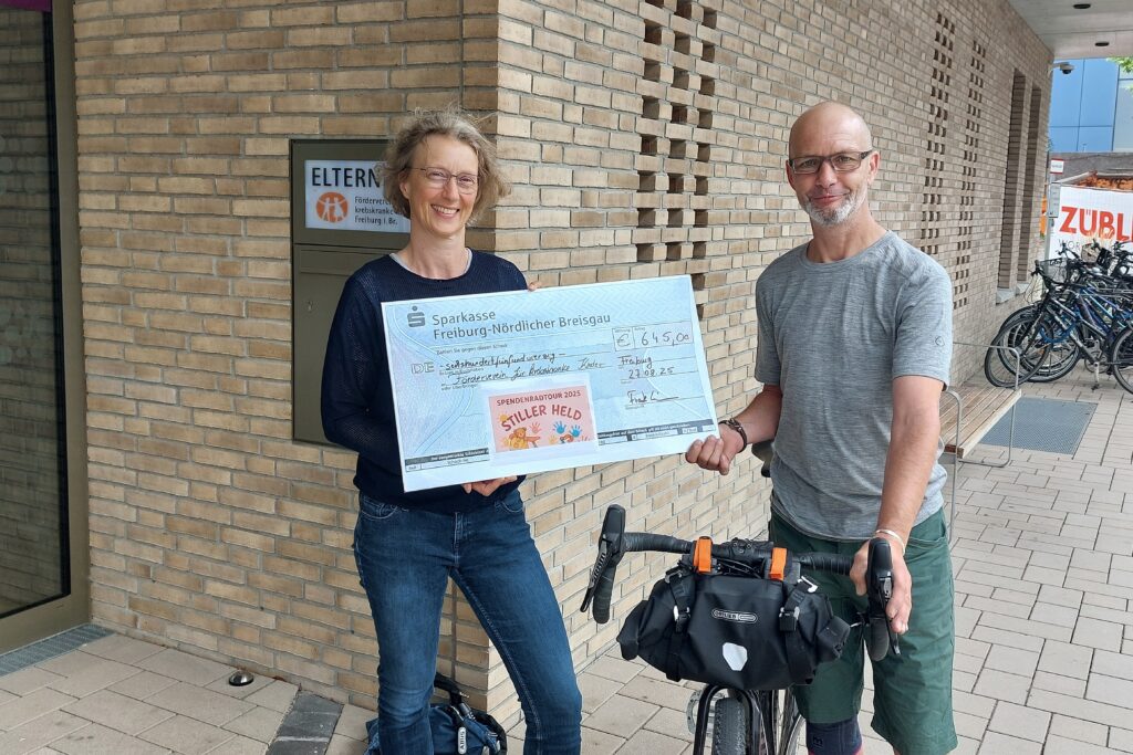 Frank Grimm mit seinem Fahrrad bei der Spendenübergabe an Andrea Schulz-Aufrecht vom Förderverein für krebskranke Kinder Freiburg e.V.